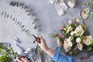 Una persona cortando flores con tijeras en una mesa