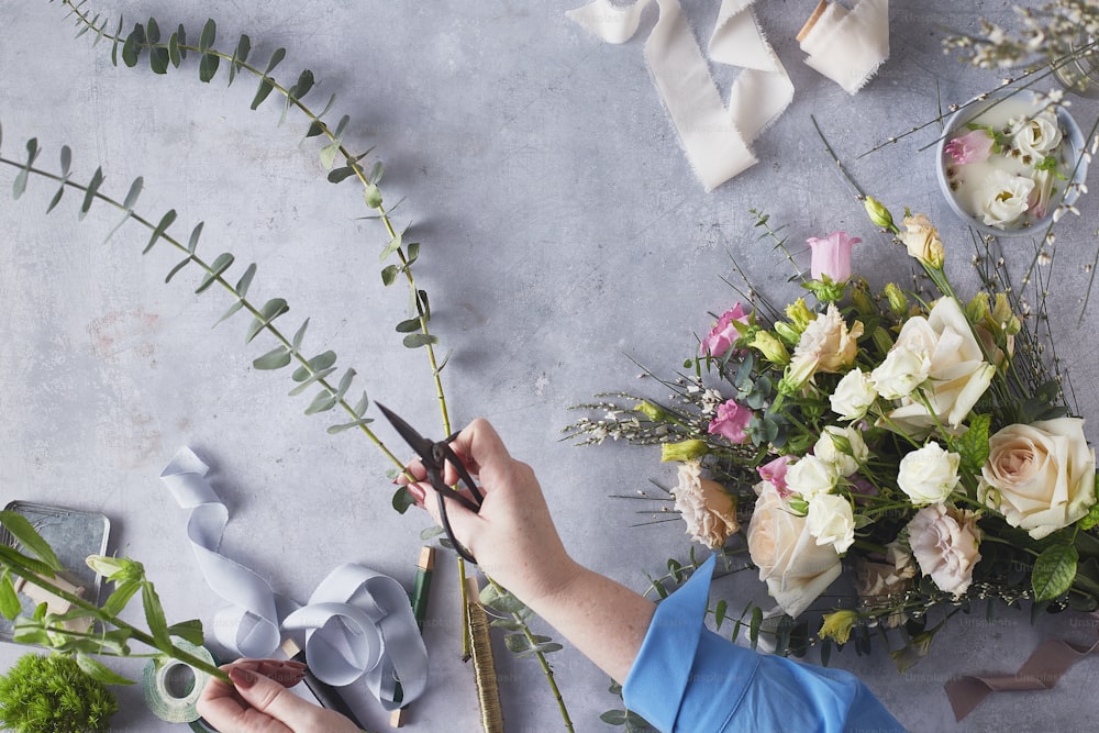 a person cutting flowers with scissors on a table