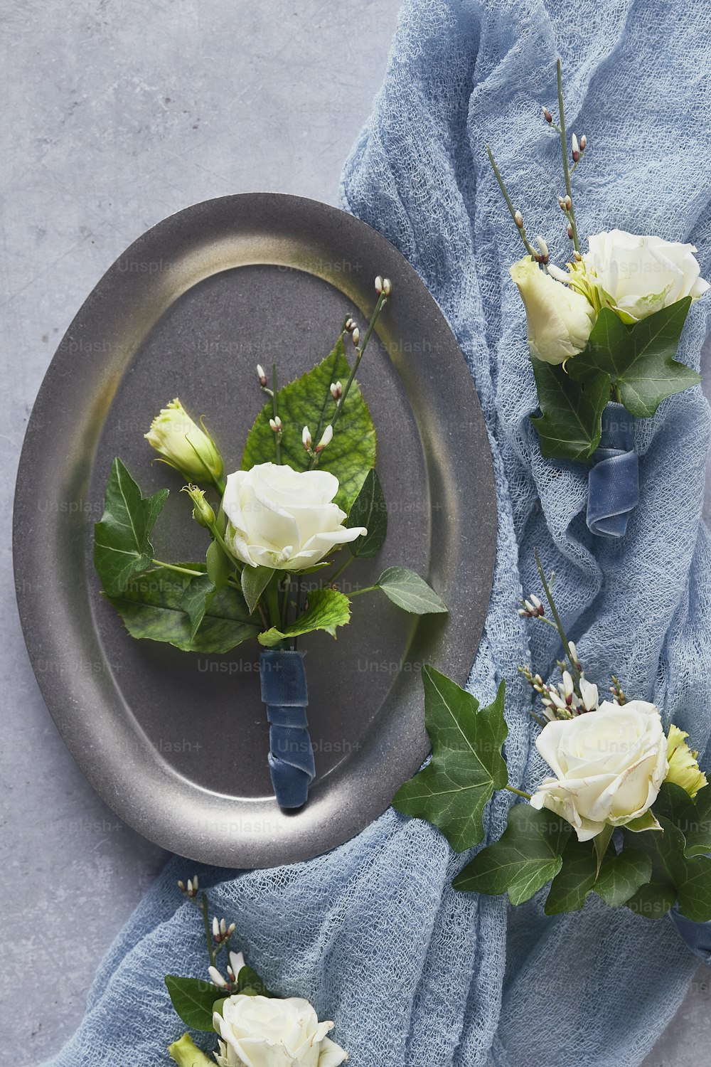 3本の白いバラが皿の上に置かれます
