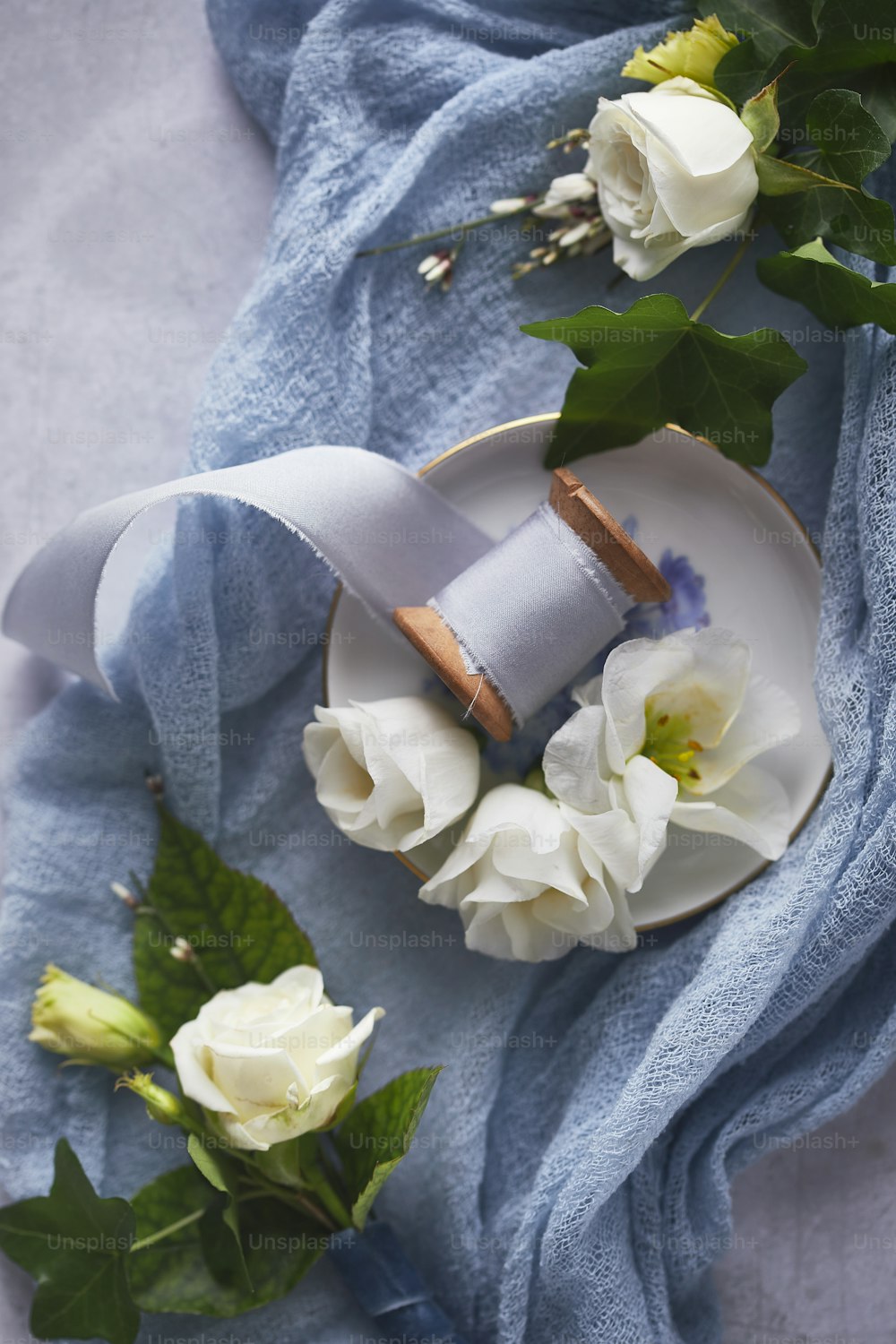 a plate with flowers and a roll of ribbon on it