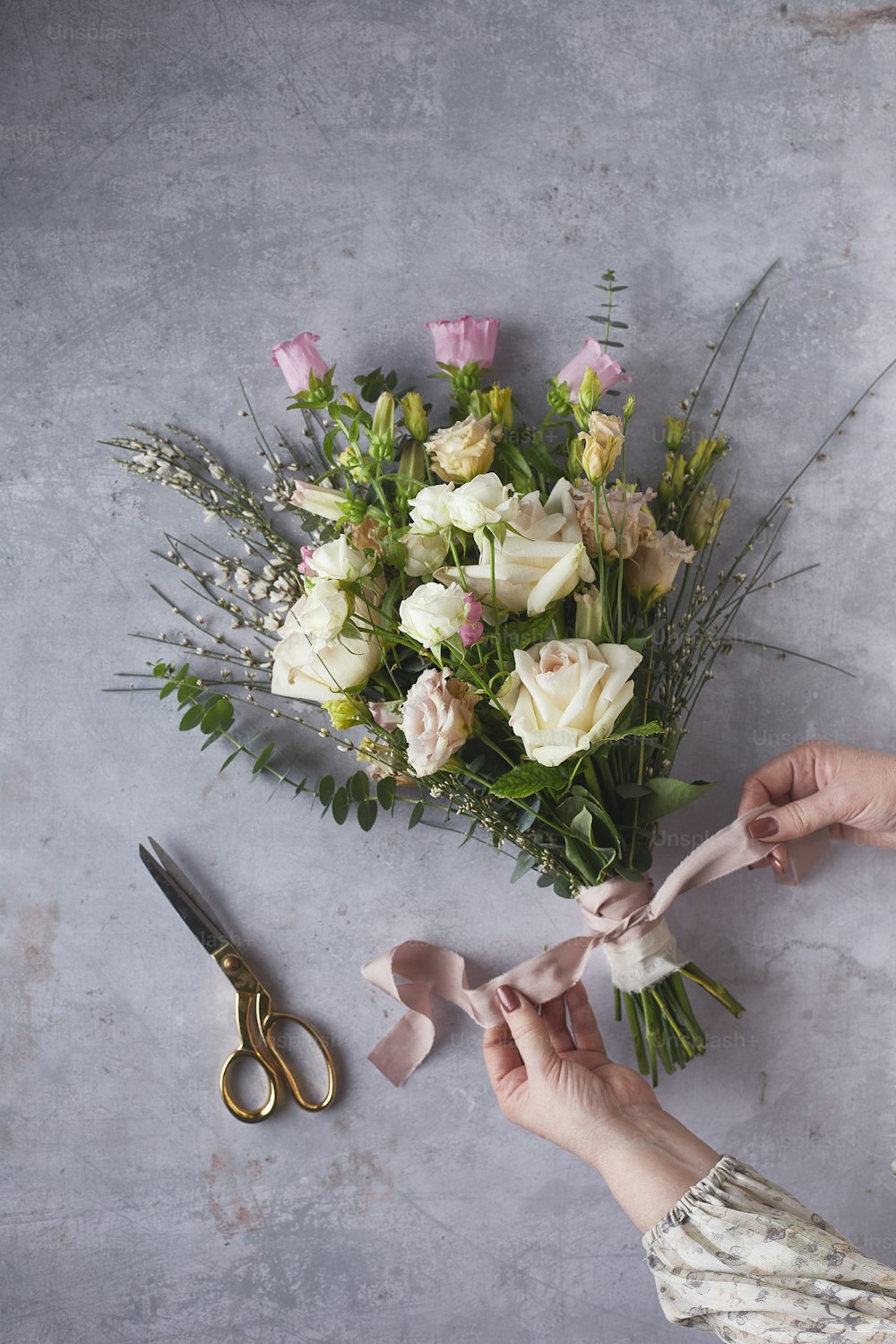 une personne coupant des fleurs avec des ciseaux sur une table