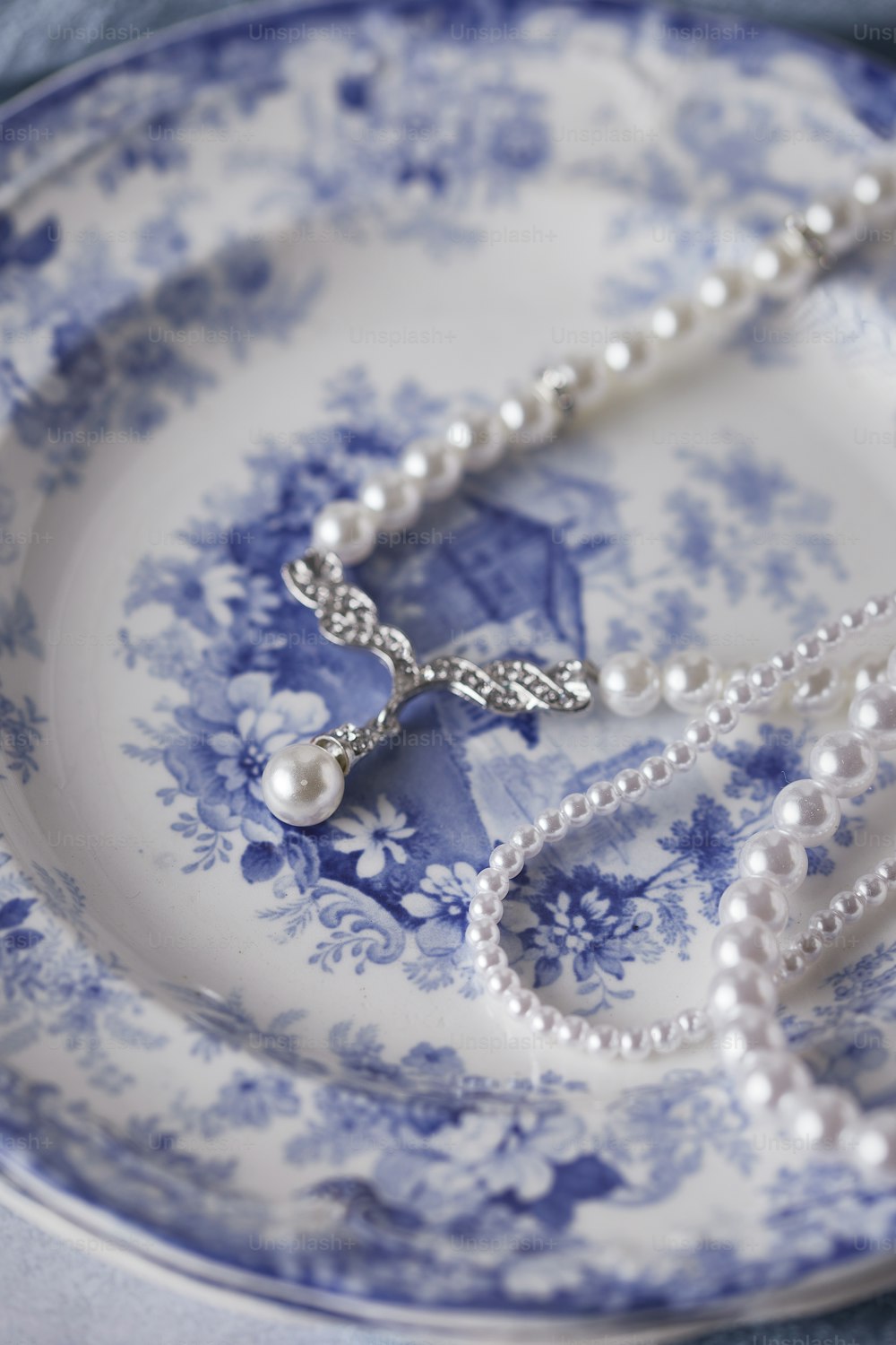 a blue and white plate with a necklace on it