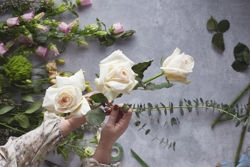 a person holding a bouquet of white roses