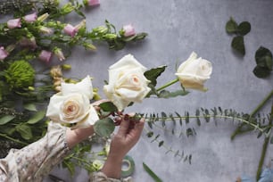 une personne tenant un bouquet de roses blanches