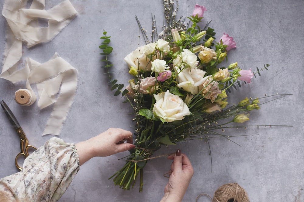 a person is arranging flowers on a table