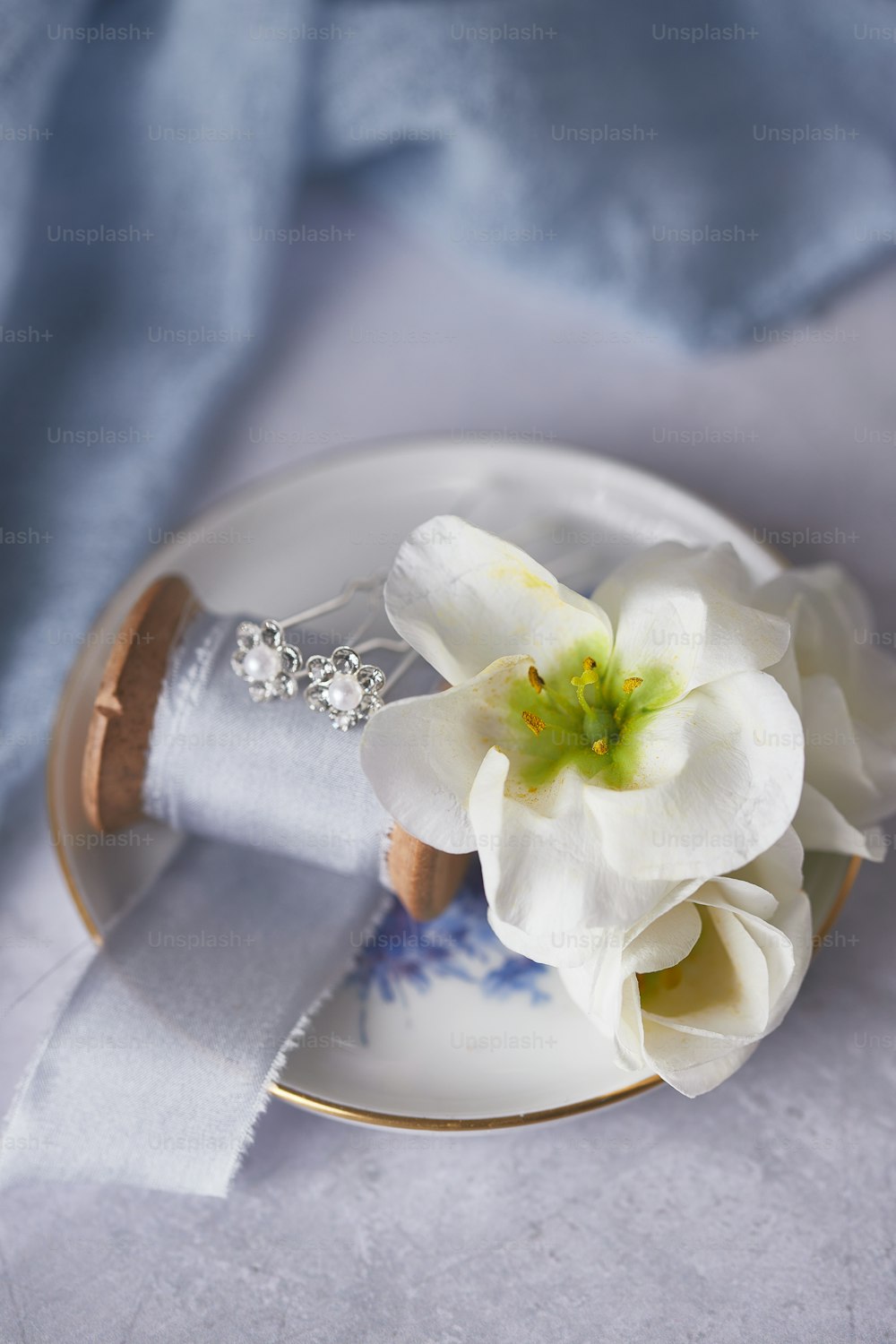 Una flor blanca sentada encima de un plato blanco