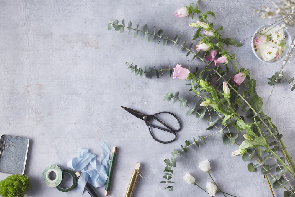 a table with flowers, scissors, and other items on it