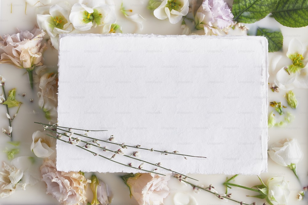 ein weißes Blatt Papier, umgeben von Blumen