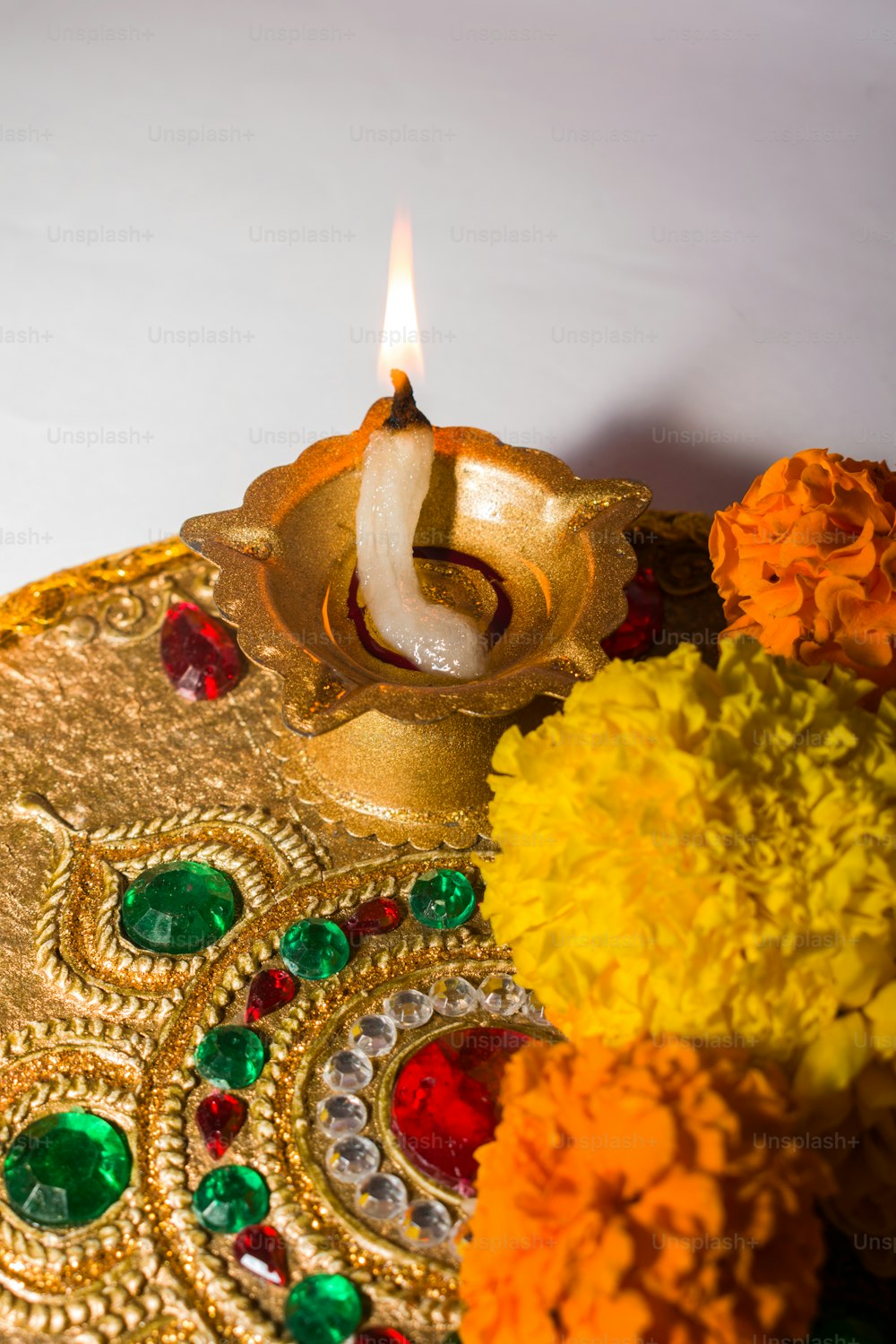 a lit candle sitting on top of a decorative plate