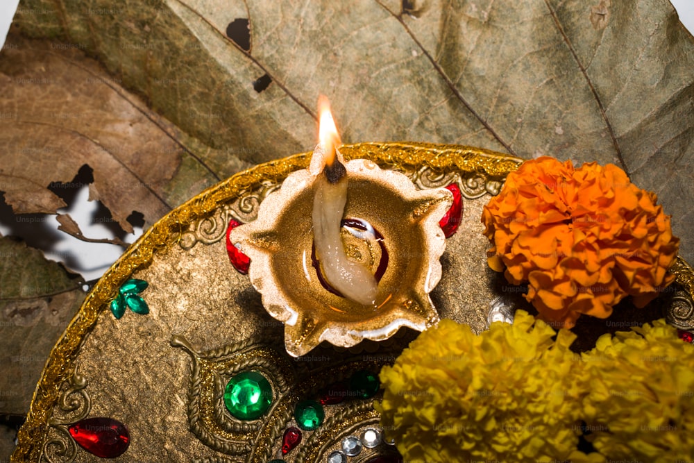 una piccola candela seduta sopra un piatto decorativo