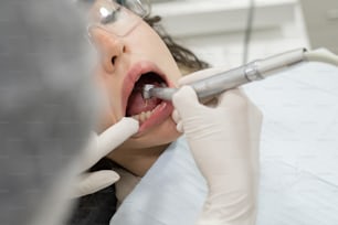 a woman getting her teeth checked by a dentist