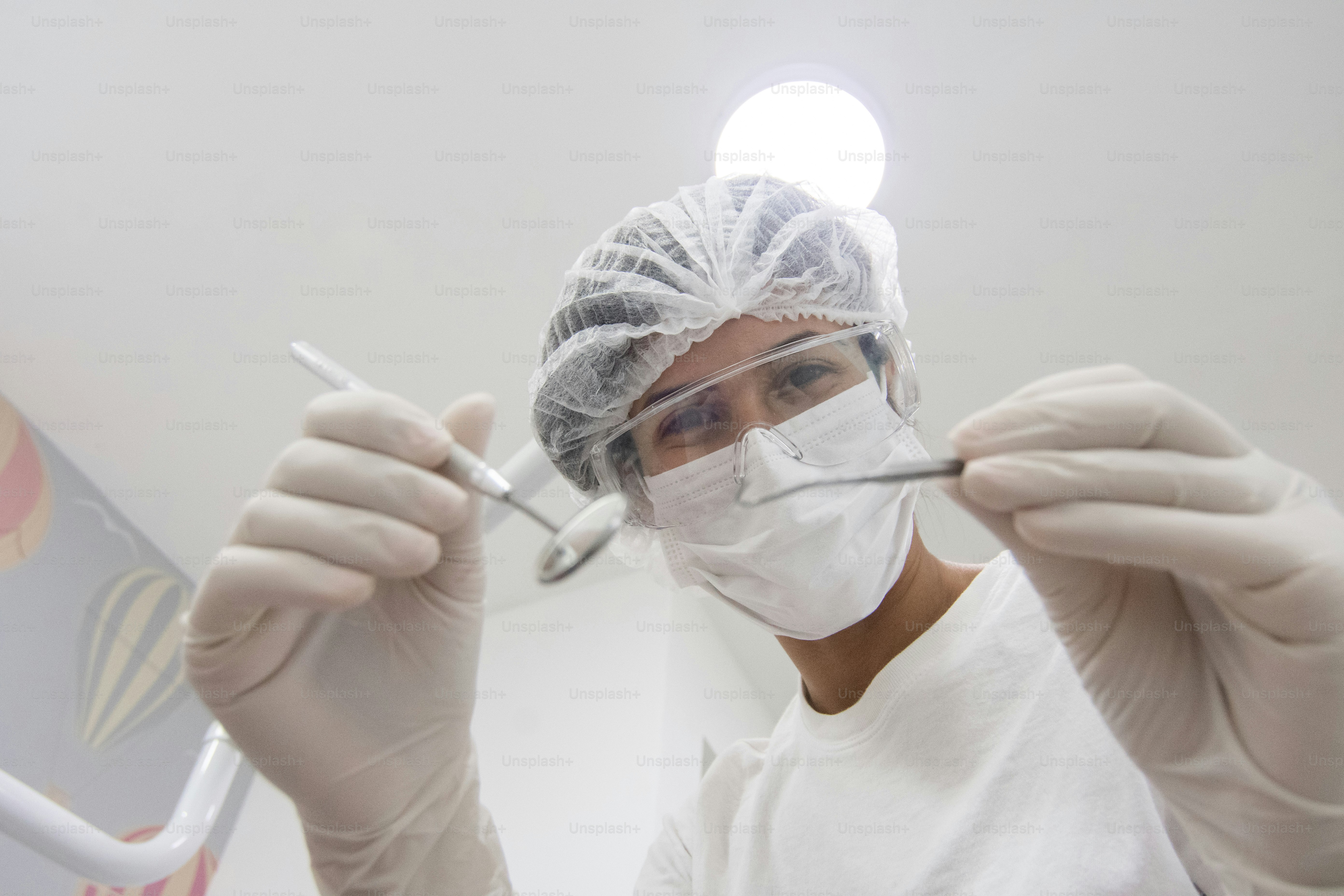 une personne portant un masque chirurgical et tenant une paire de ciseaux