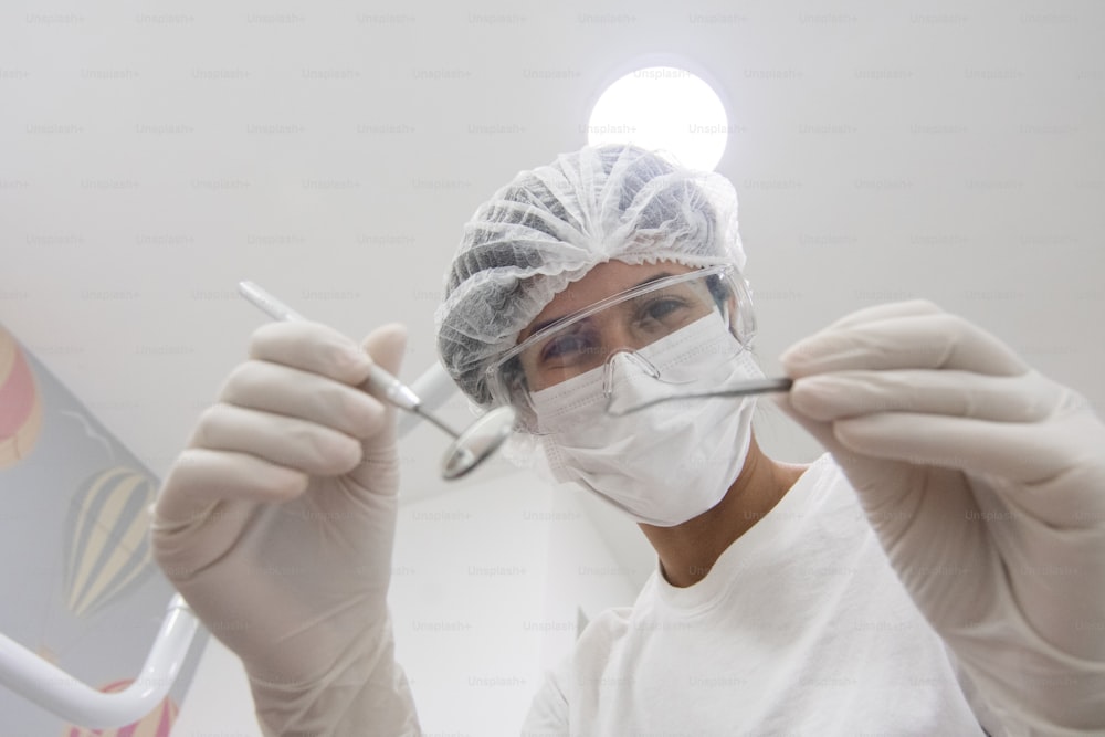 a person wearing a surgical mask and holding a pair of scissors