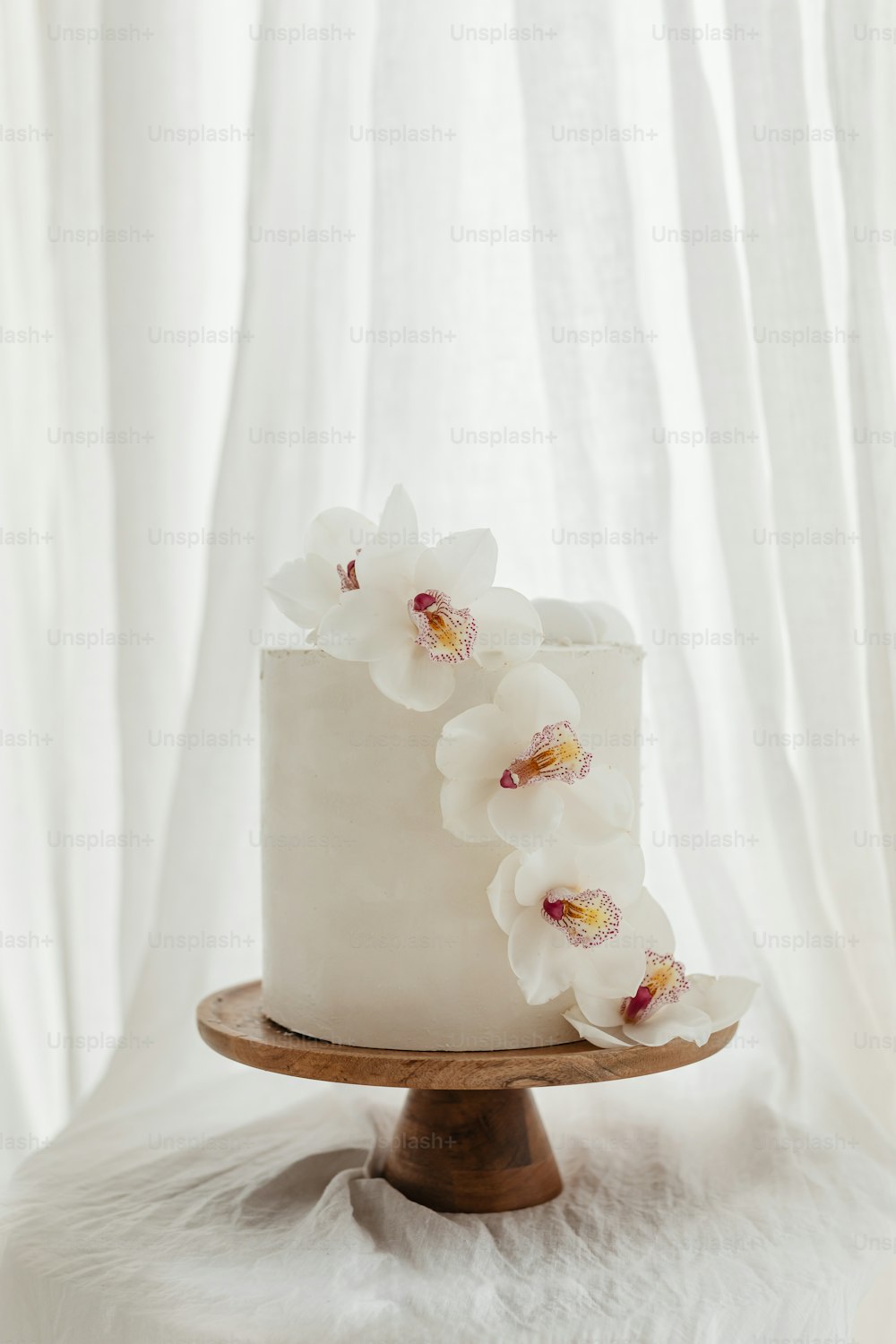 Un pastel blanco con flores blancas en la parte superior