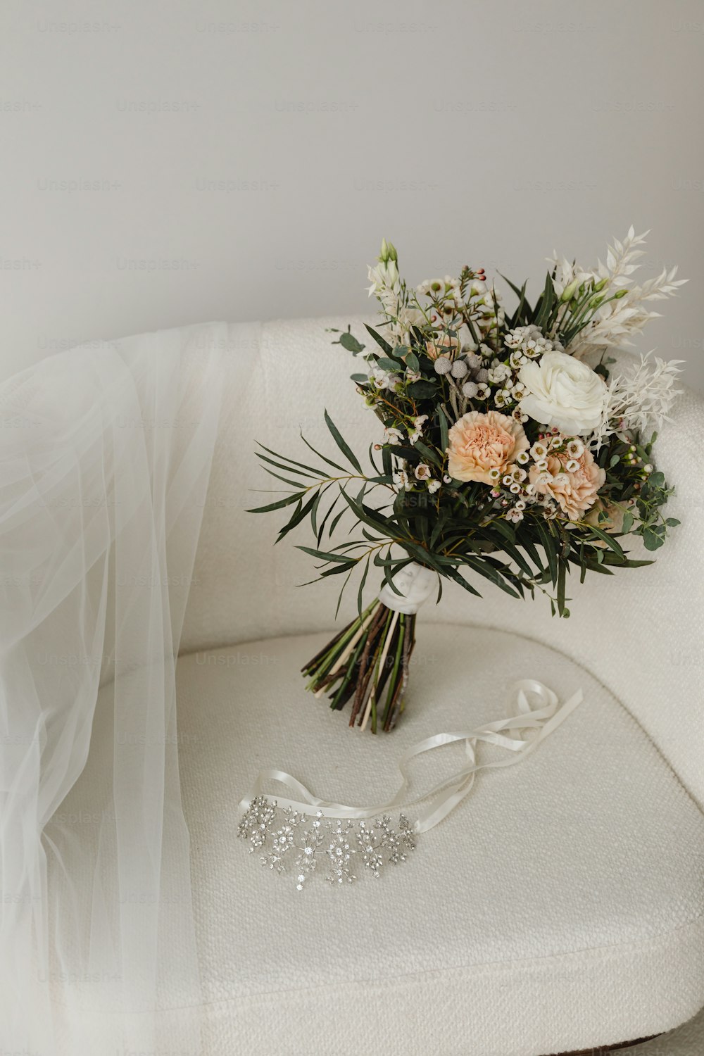 a bridal bouquet sitting on a white chair