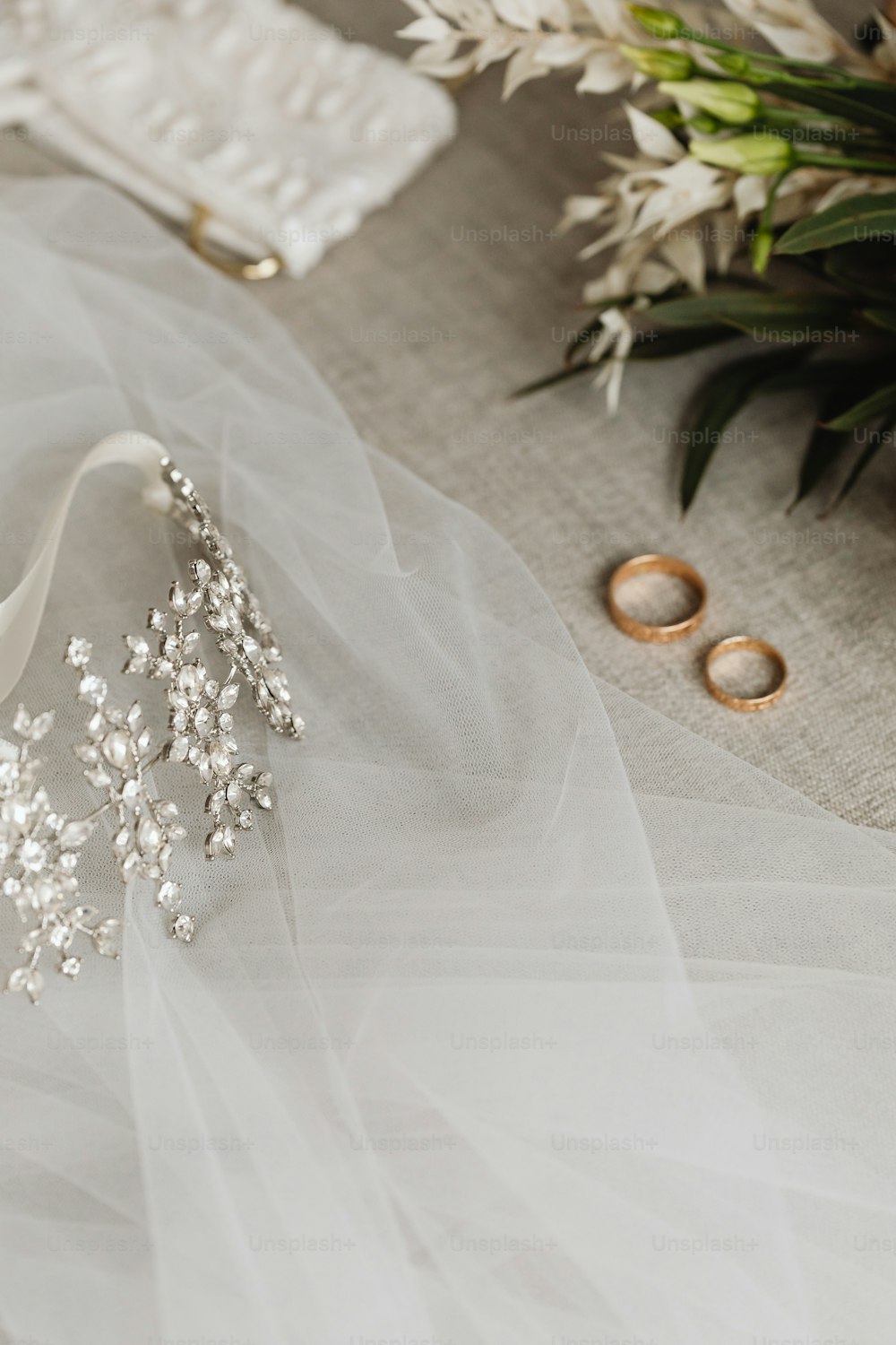 a wedding dress and two wedding rings on a table