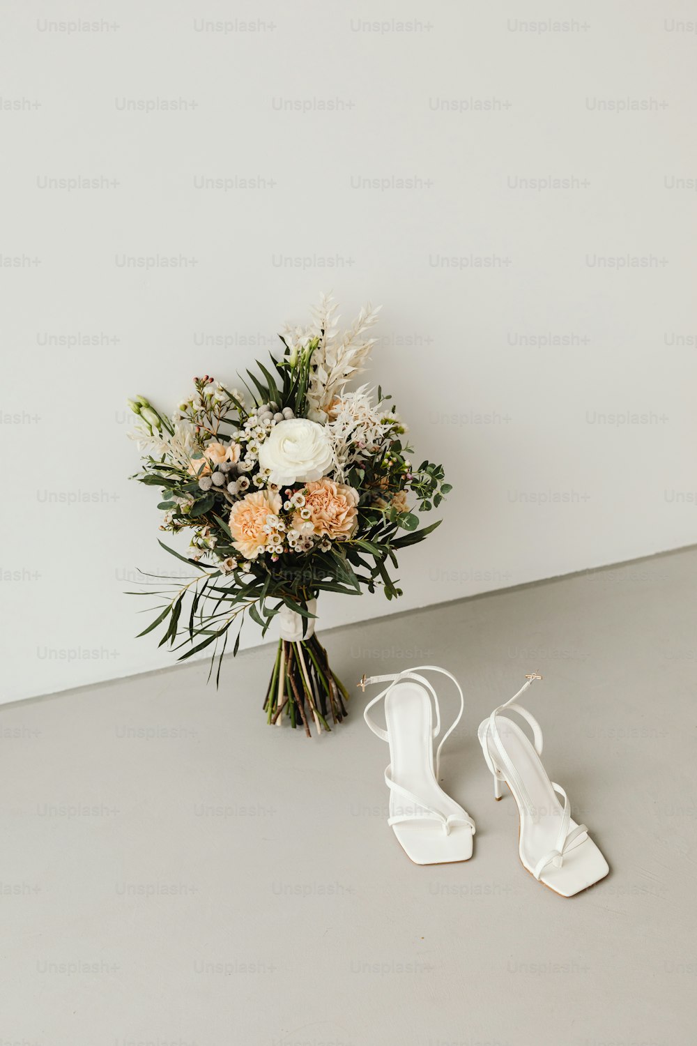 un ramo de flores y un par de zapatos blancos