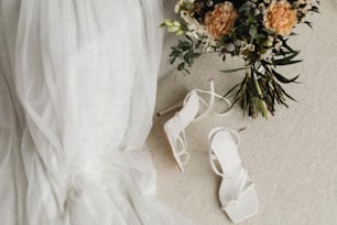 sapatos de uma noiva e buquê de flores no chão