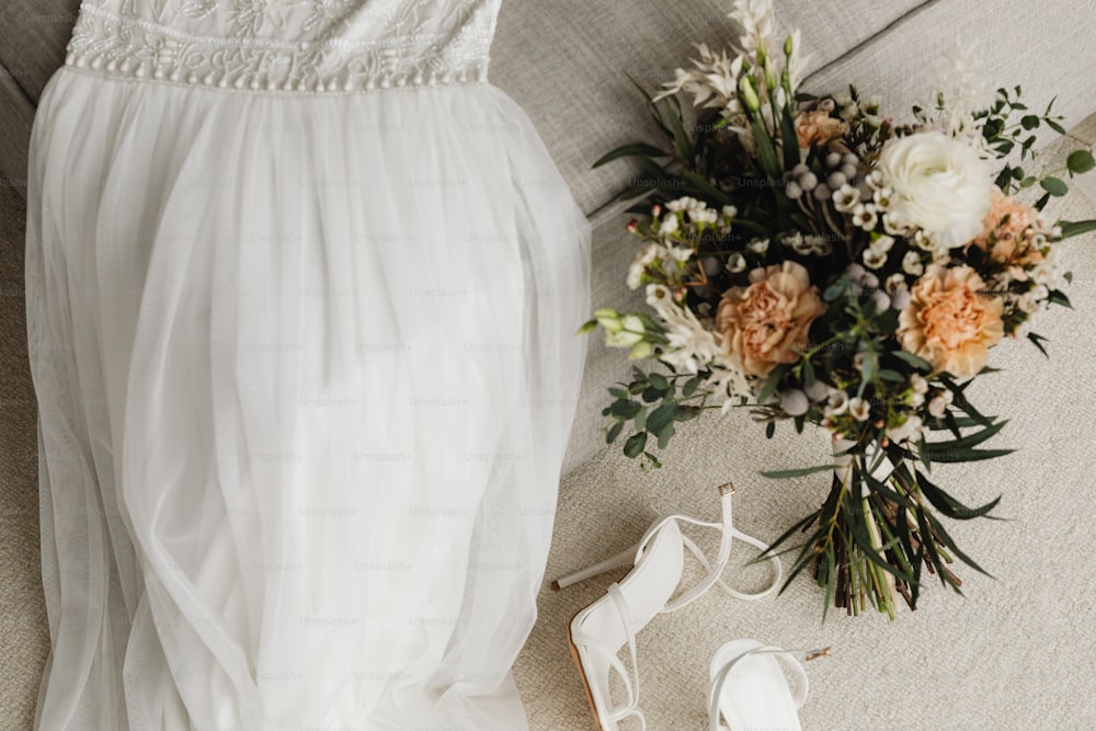 a wedding dress and shoes on a couch