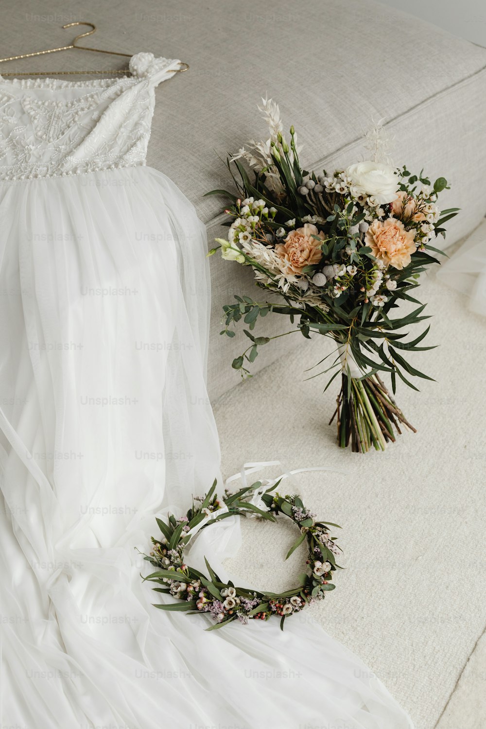 a bride's dress and flowers on a couch