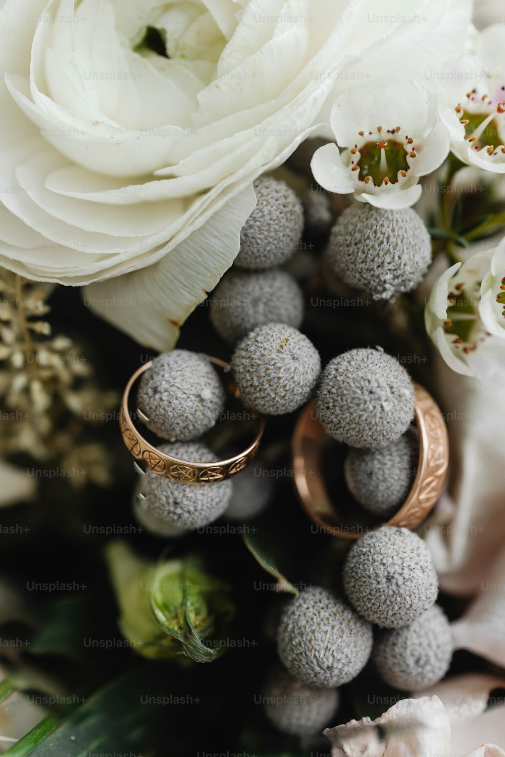 a bouquet of flowers and two wedding rings