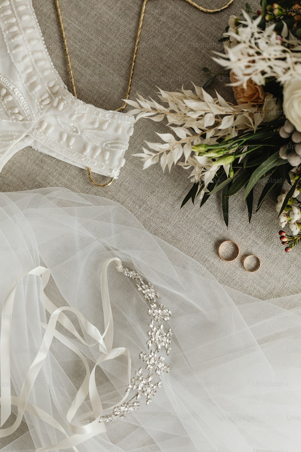 a bridal dress and wedding accessories on a table