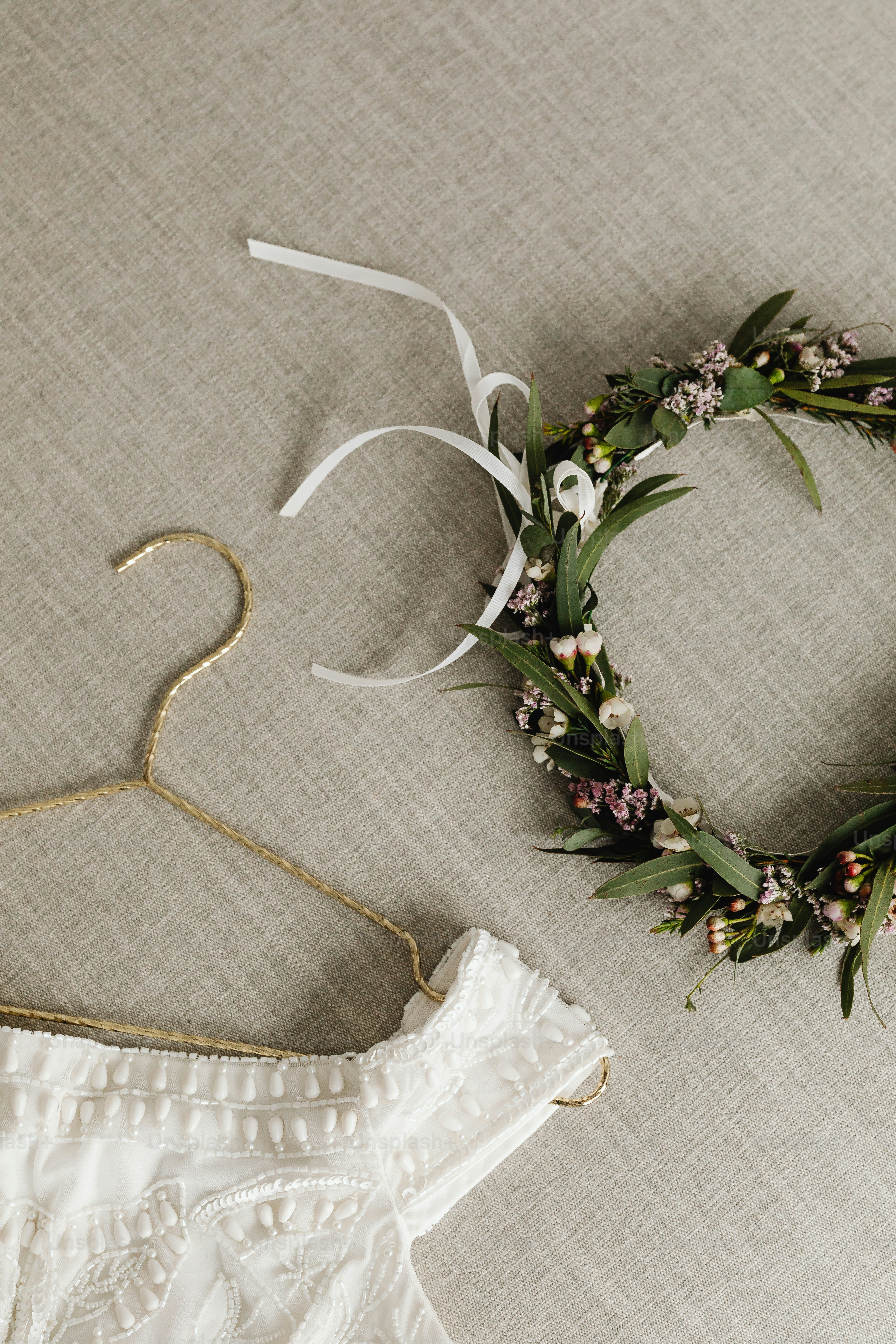 a white dress and a wreath on a bed
