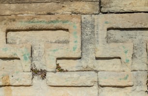 a close up of a stone wall with a clock on it