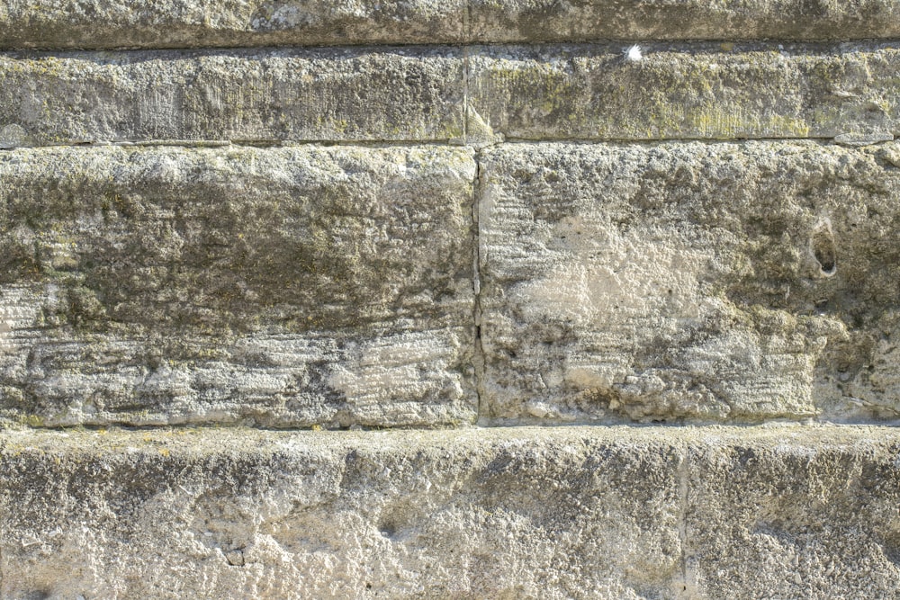 a close up of a stone wall with a clock on it