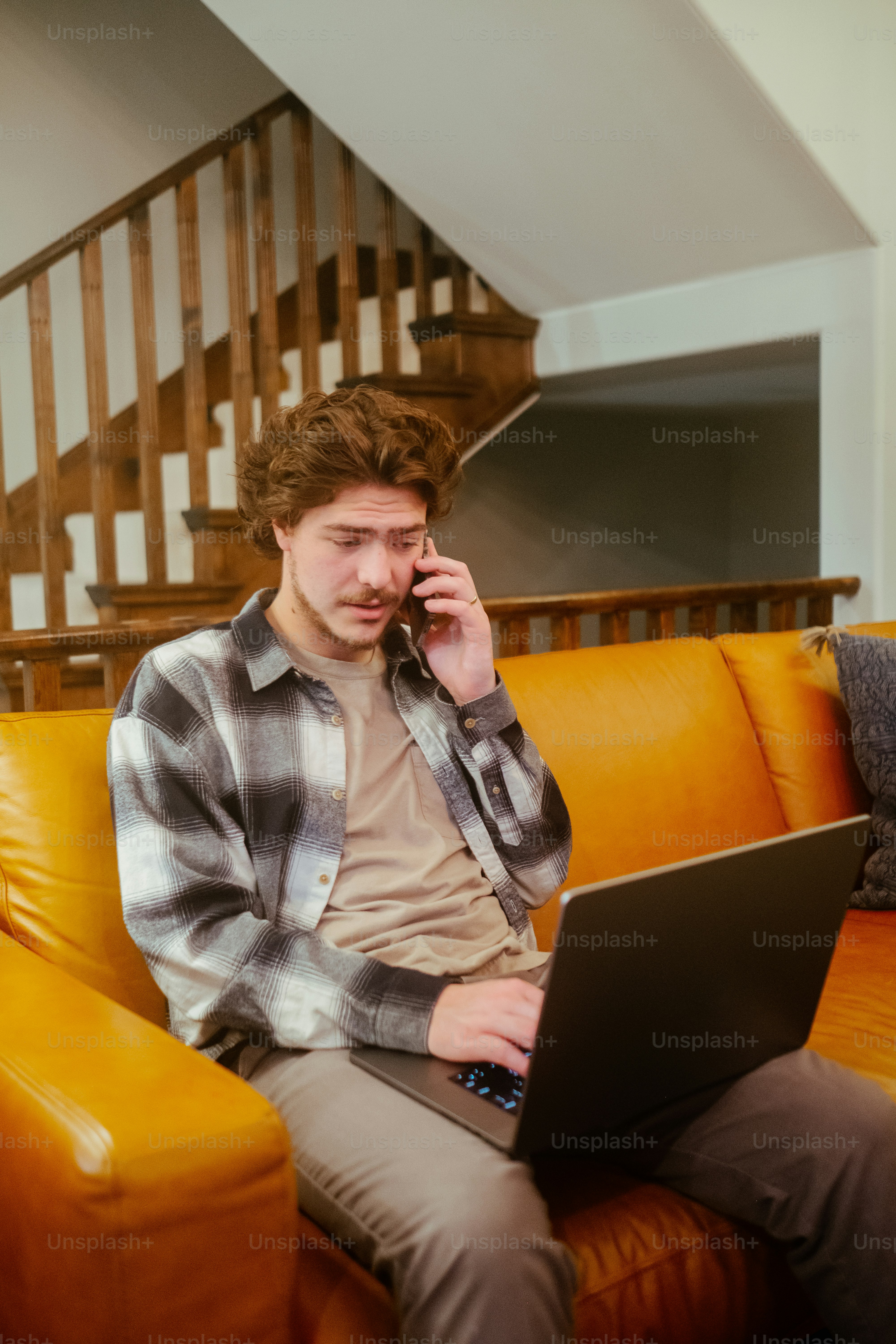 a man sitting on a couch using a laptop computer