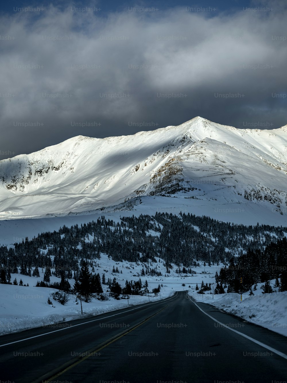 a snow covered mountain with a road in the foreground