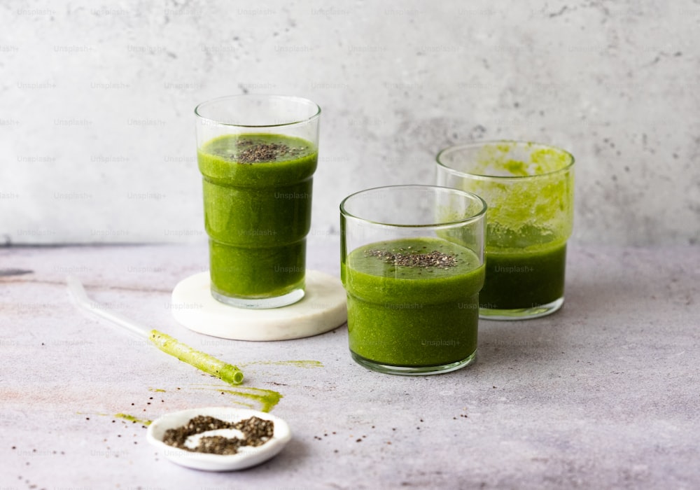 a couple of glasses filled with green liquid