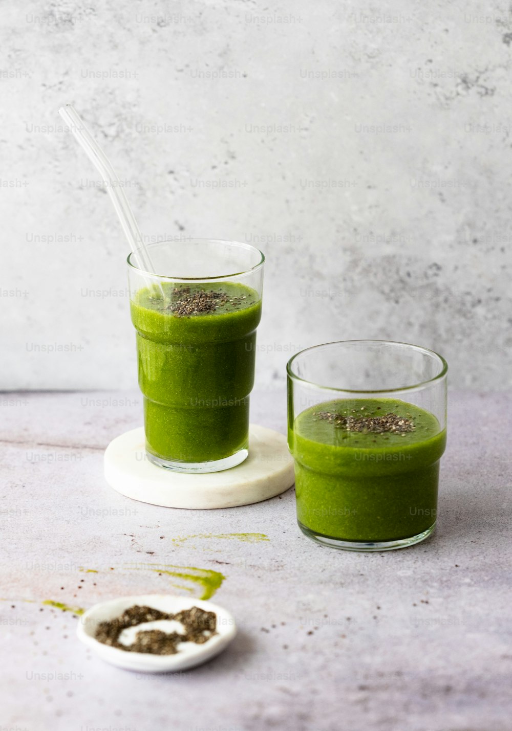 um par de copos cheios de smoothie verde