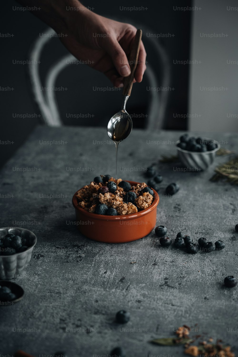 a person is spooning blueberries into a bowl
