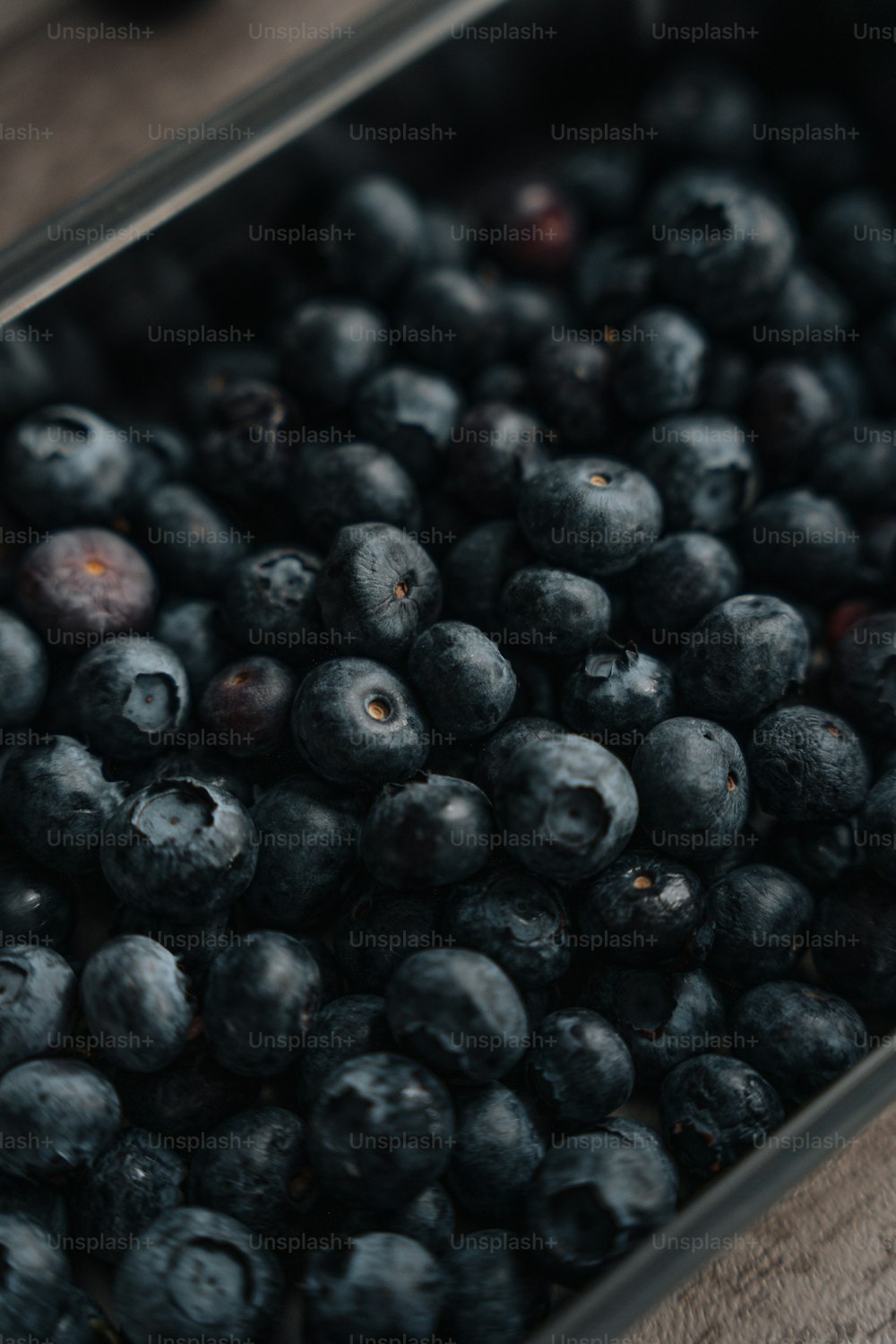 a close up of blueberries in a metal container