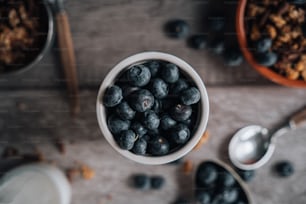 a bowl filled with blueberries next to a spoon