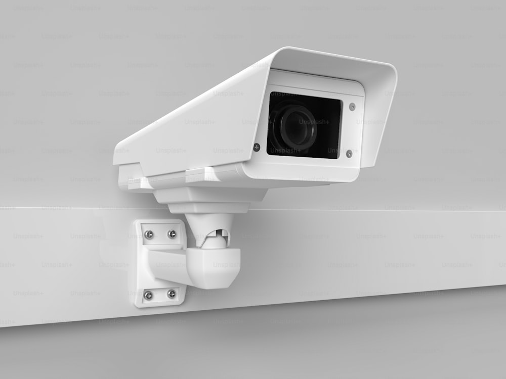 eine weiße Überwachungskamera an einer Wand montiert