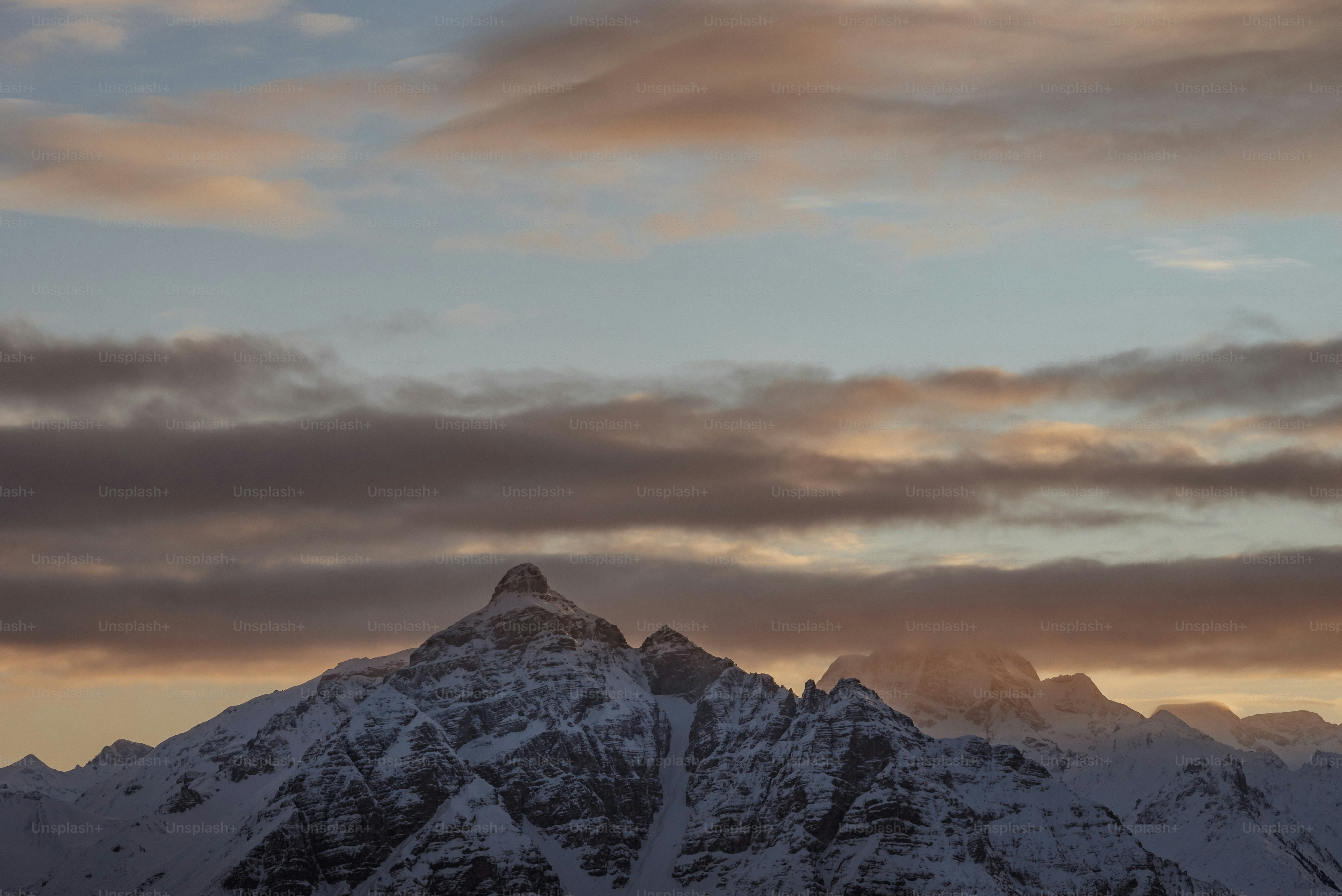 uma grande montanha coberta de neve sob um céu nublado