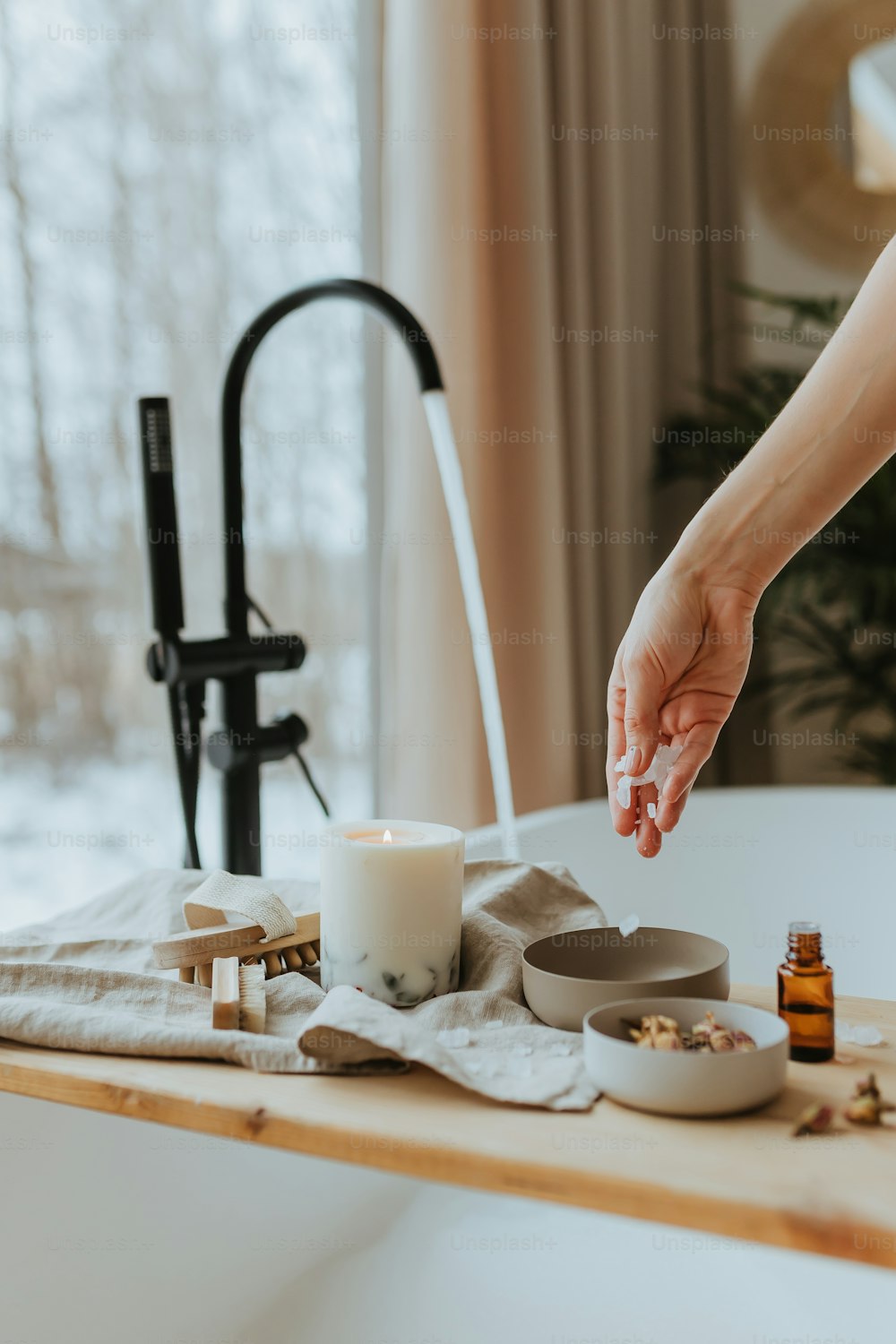 a person reaching for a candle on a table