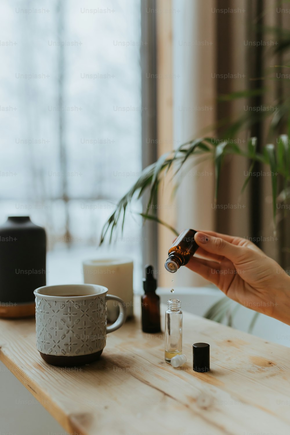 a woman is holding a bottle of essential oils