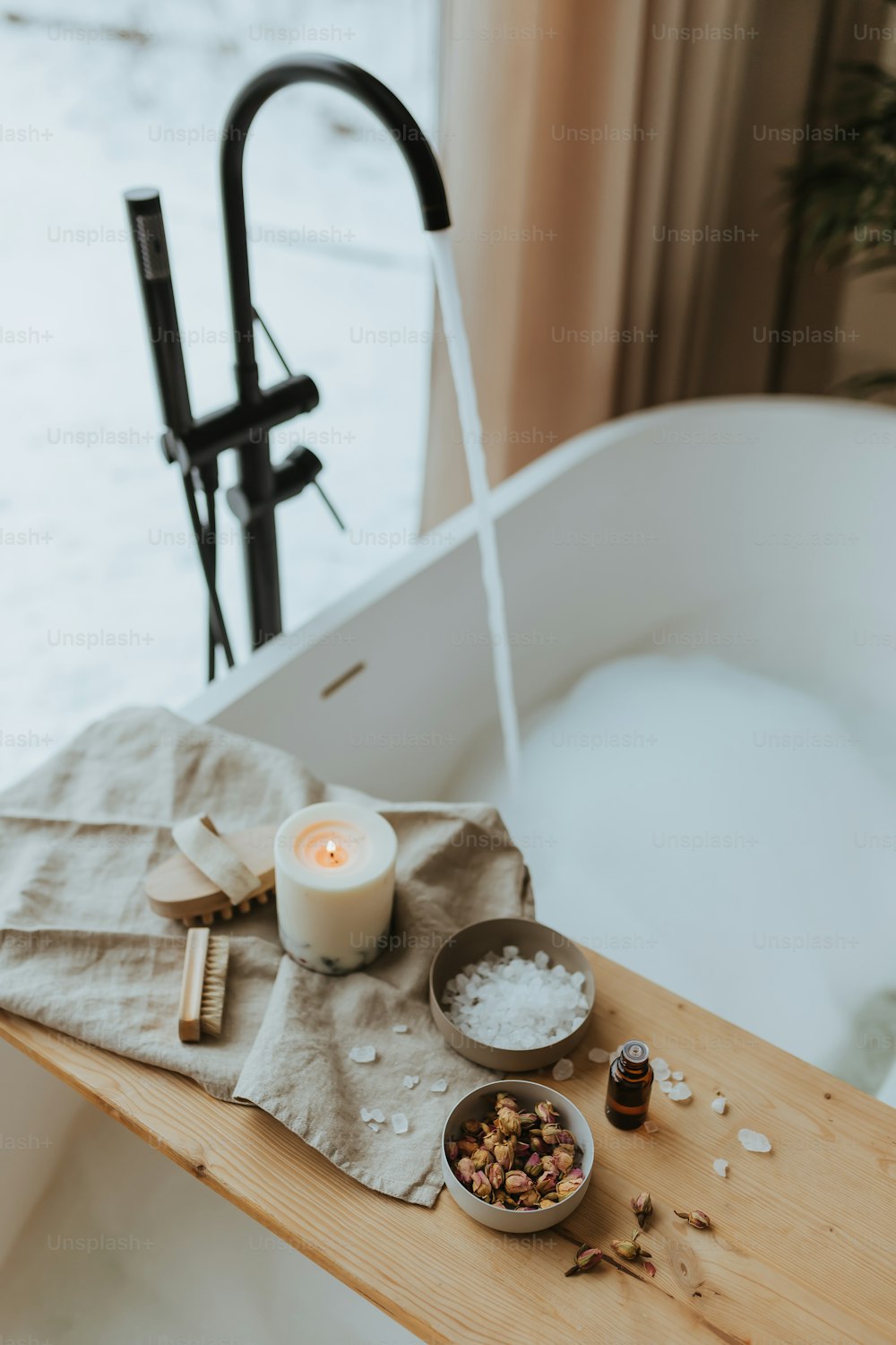 a wooden table topped with a bowl of food next to a candle