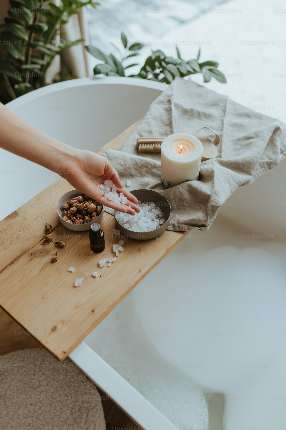 a person reaching for a bowl of food in a bathtub