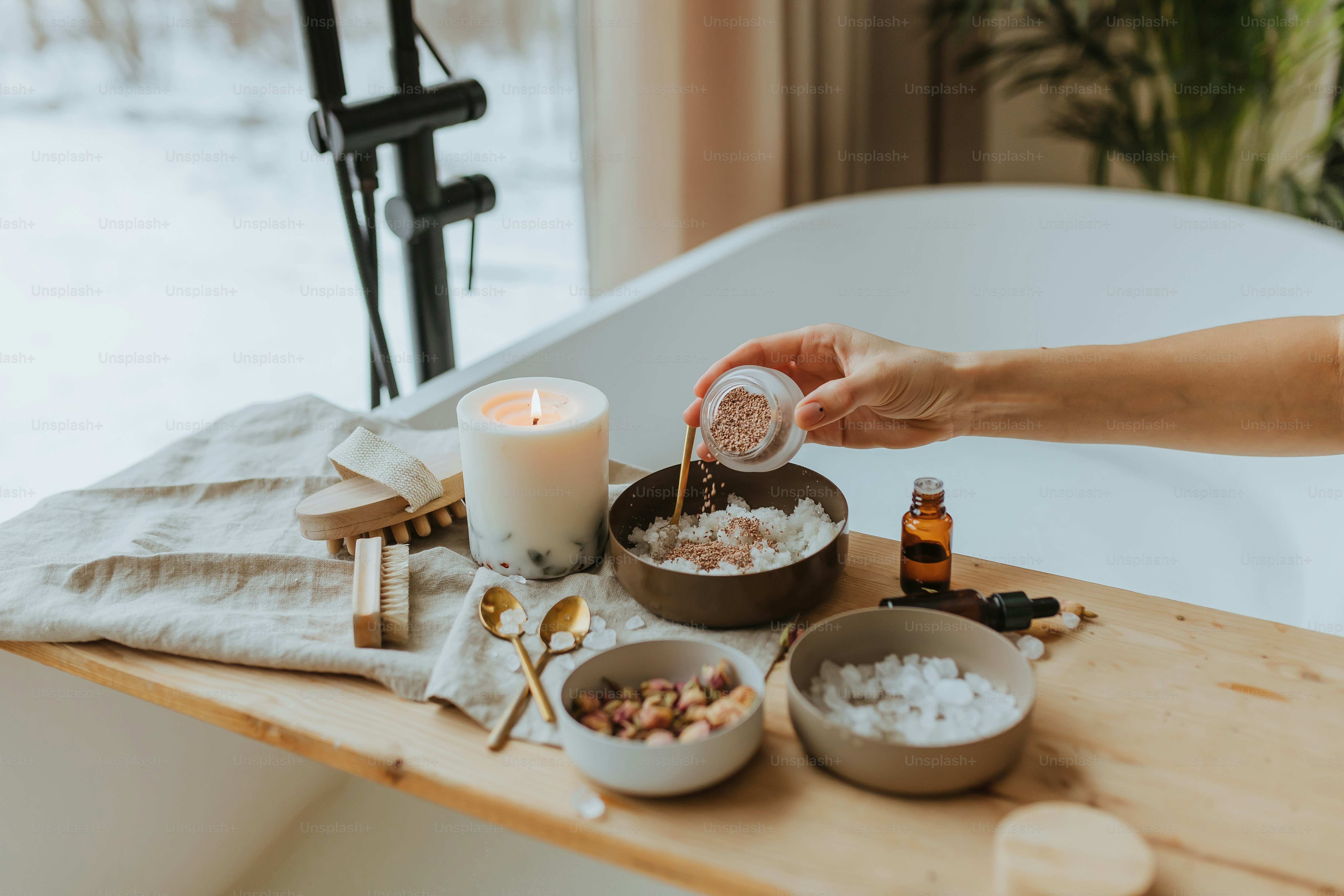 a person pouring sugar into a bowl next to a candle