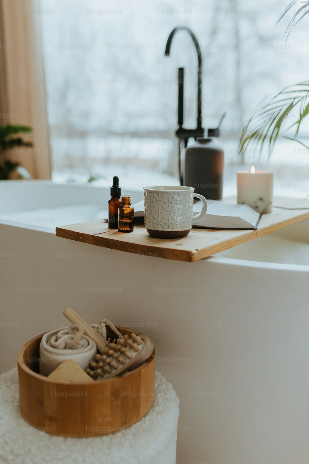 a bath tub with a wooden tray and a cup on top of it