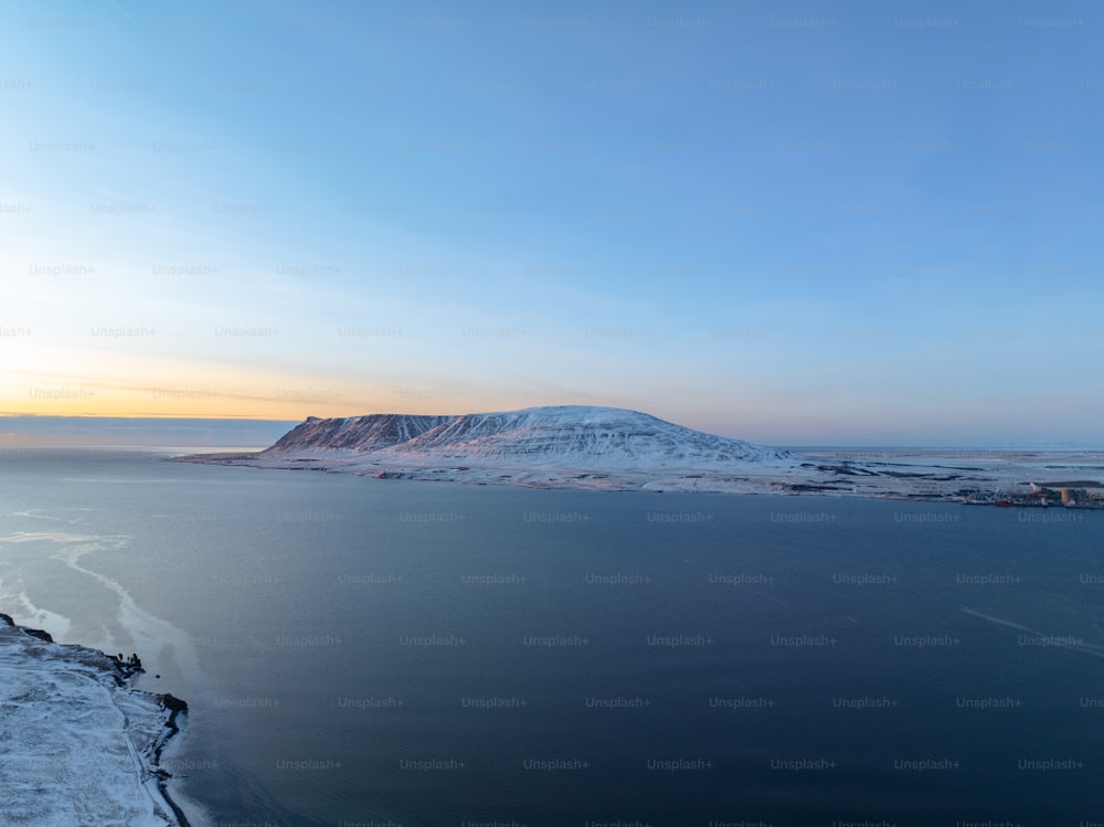 a large body of water with a mountain in the background