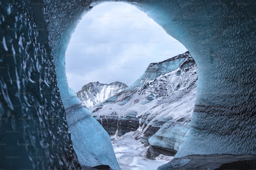 uma grande caverna de gelo com uma montanha ao fundo