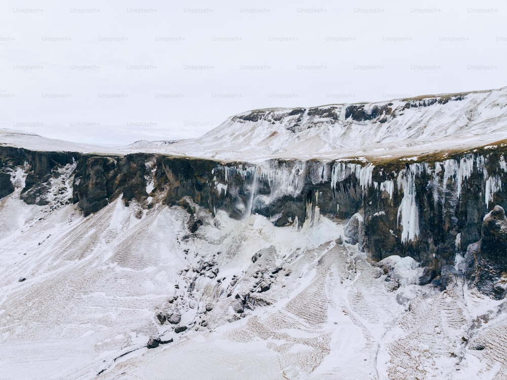 Una montagna coperta di ghiaccio e neve accanto a una scogliera