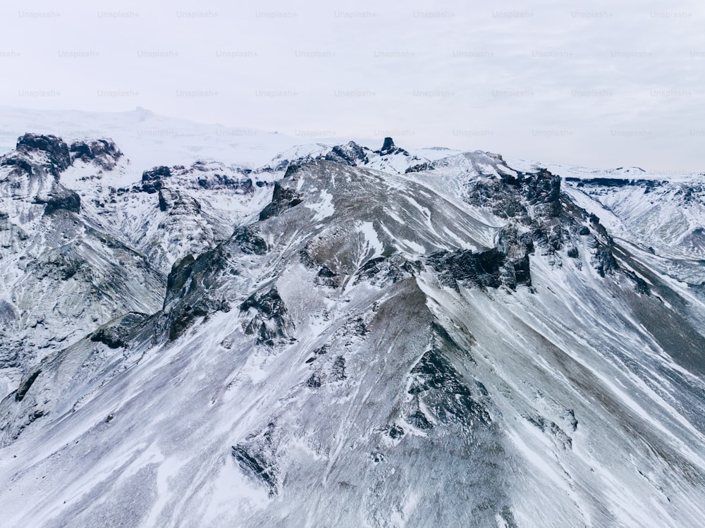 a mountain covered in snow under a cloudy sky