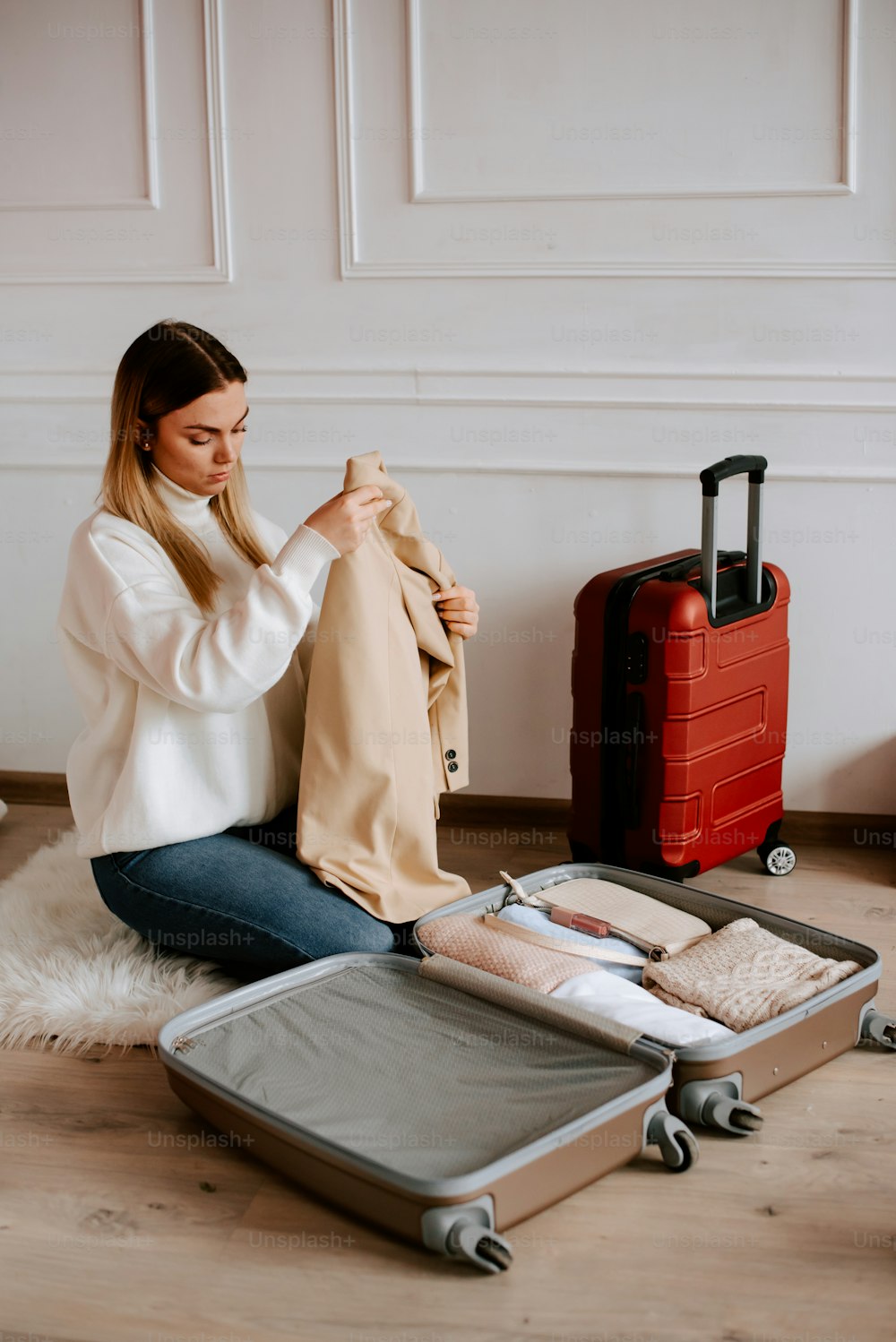 a woman sitting on the floor with her luggage