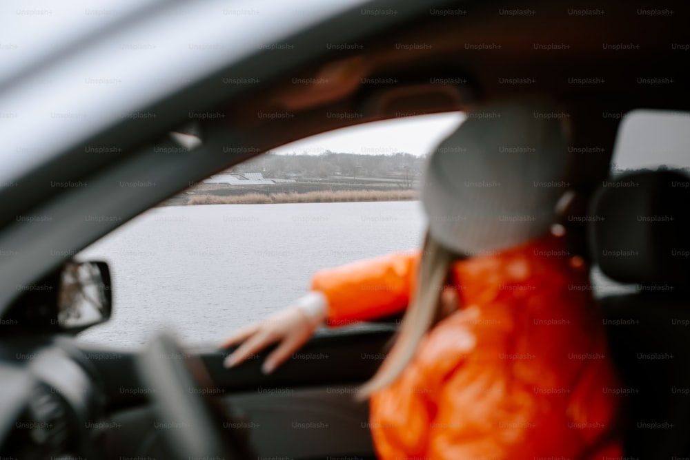 uma mulher sentada em um carro olhando pela janela